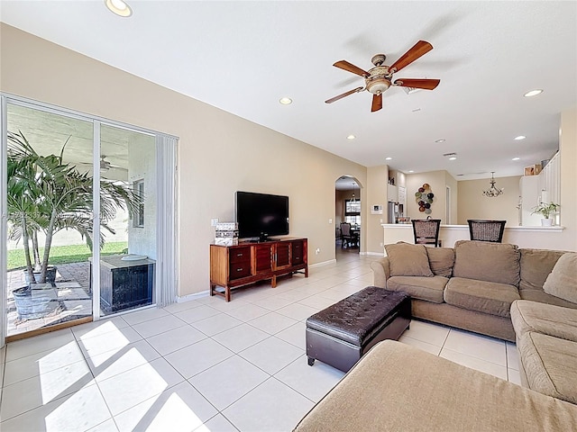 living room with baseboards, ceiling fan, recessed lighting, light tile patterned flooring, and arched walkways