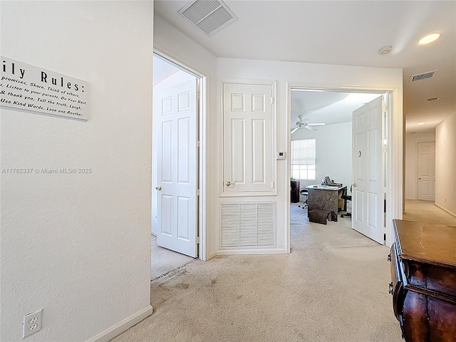 corridor with carpet, visible vents, and baseboards