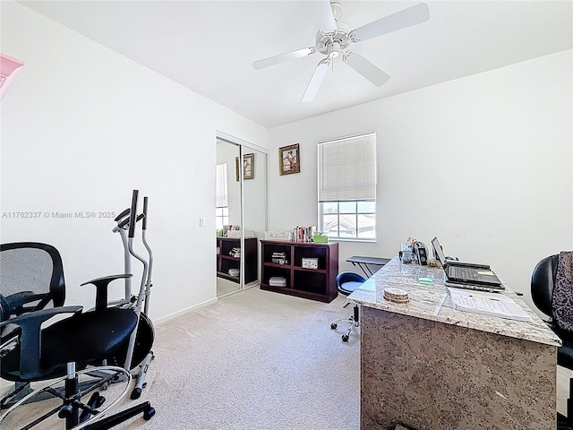 office featuring baseboards, light colored carpet, and a ceiling fan