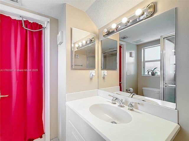 bathroom featuring vanity, visible vents, lofted ceiling, a textured ceiling, and toilet