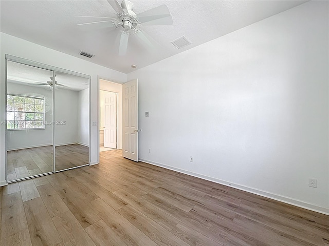 2217 SW Newport Isles Blvd, Port St Lucie, FL 34953 - unfurnished bedroom featuring wood finished floors, a closet, and a ceiling fan