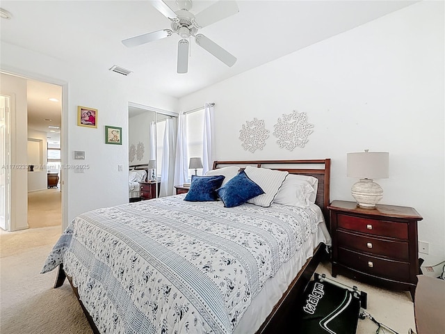 bedroom with a ceiling fan, visible vents, a closet, light carpet, and multiple windows