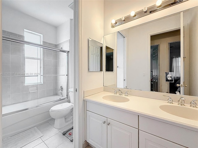 full bathroom featuring a sink, toilet, double vanity, and tile patterned floors