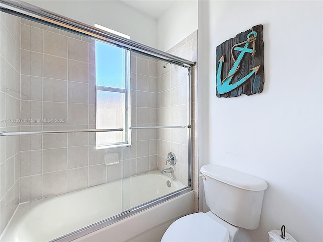 full bathroom with toilet and bath / shower combo with glass door