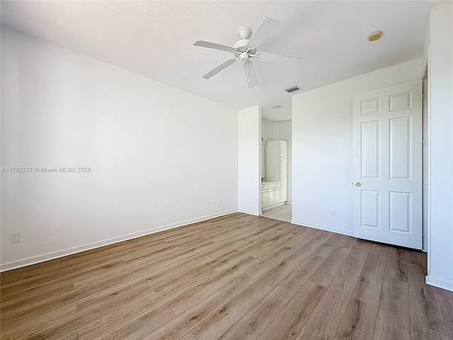2217 SW Newport Isles Blvd, Port St Lucie, FL 34953 - unfurnished bedroom featuring light wood-style floors, ensuite bath, and a ceiling fan
