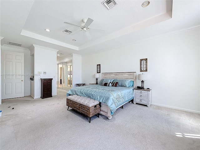 bedroom featuring a tray ceiling, visible vents, and carpet floors