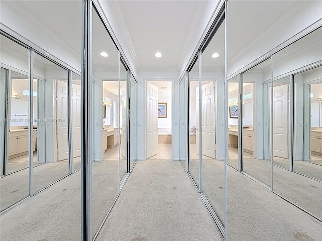 hallway with recessed lighting, light colored carpet, and crown molding