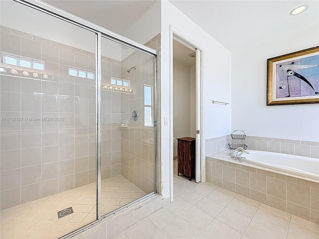 bathroom with tile patterned floors, a bath, and a stall shower