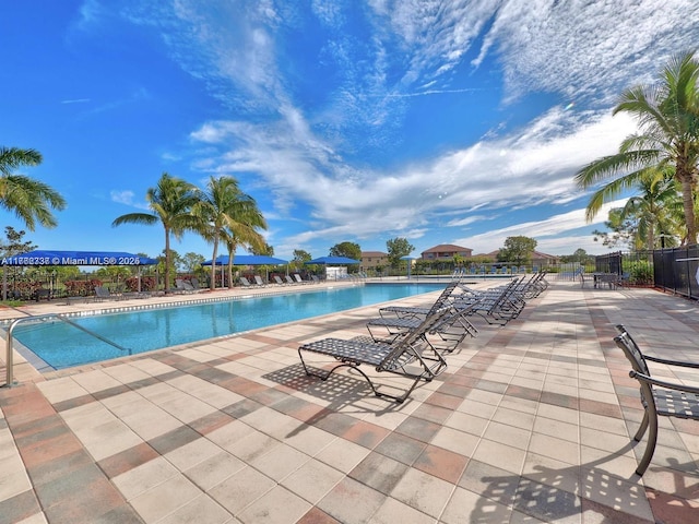 community pool featuring a patio area and fence