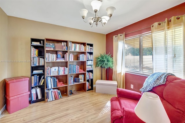 sitting room with a notable chandelier and wood finished floors