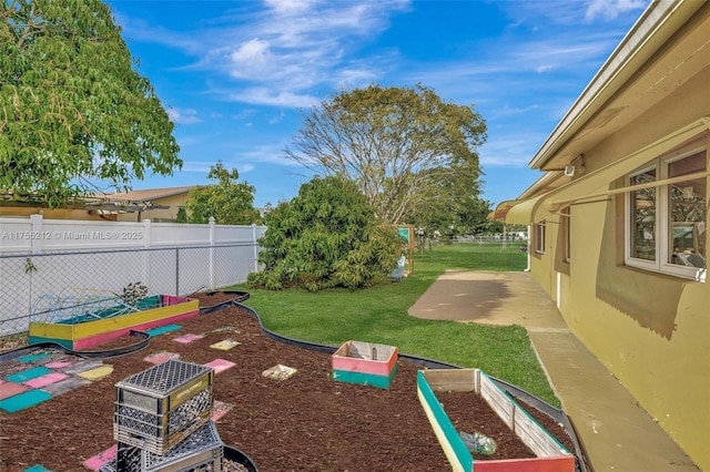 view of yard featuring a patio, a vegetable garden, and fence