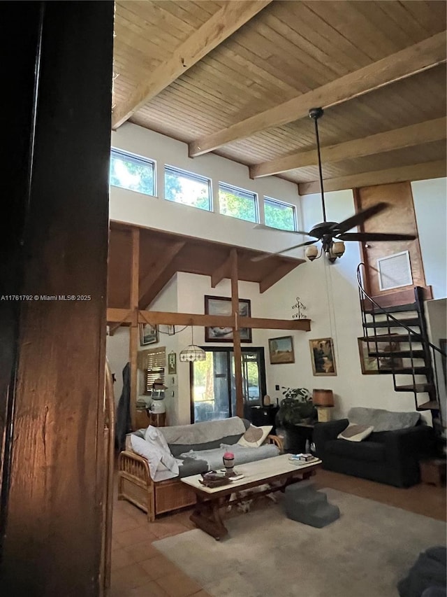 living room featuring stairway, beamed ceiling, wood ceiling, and a towering ceiling