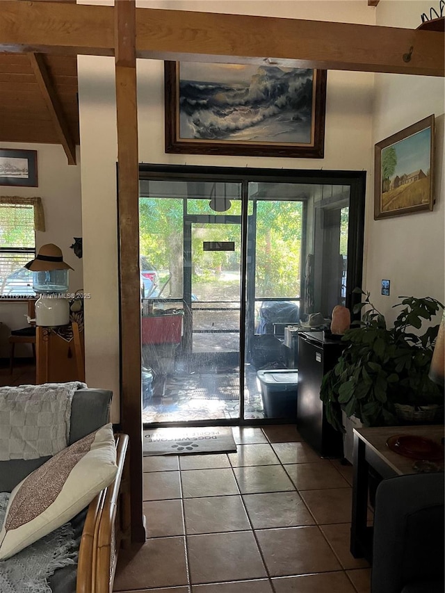 doorway featuring a wealth of natural light, beamed ceiling, and tile patterned flooring