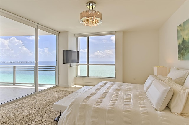 bedroom featuring access to exterior and a chandelier