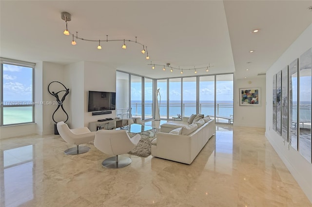 living room featuring a wall of windows, baseboards, recessed lighting, track lighting, and marble finish floor