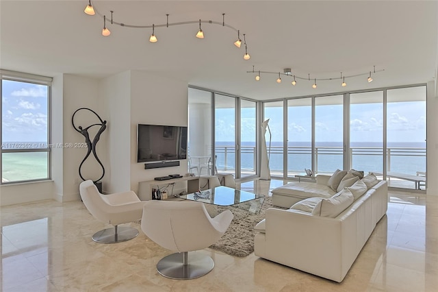 living area featuring rail lighting, floor to ceiling windows, and plenty of natural light