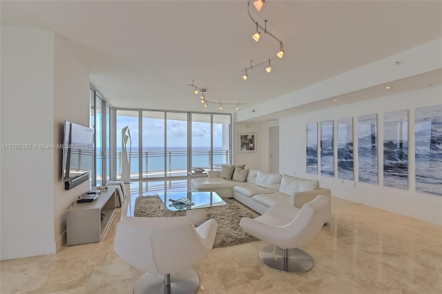 living area with track lighting, floor to ceiling windows, and baseboards