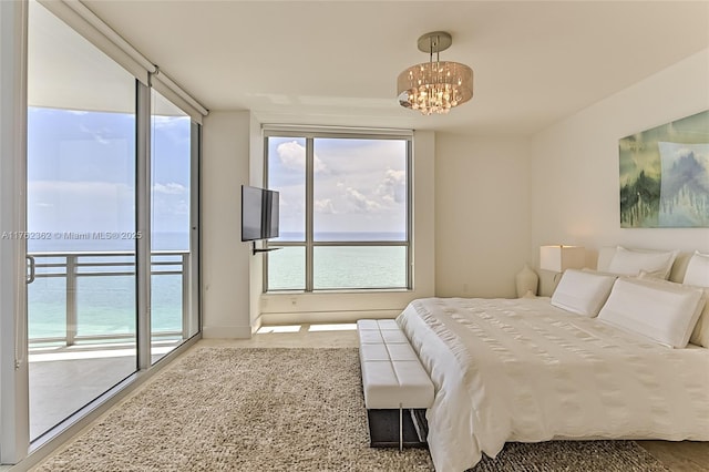 bedroom featuring access to outside and a chandelier