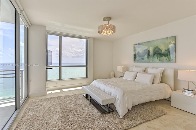 bedroom with an inviting chandelier, access to outside, and floor to ceiling windows