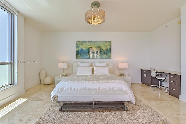 bedroom with a chandelier and baseboards