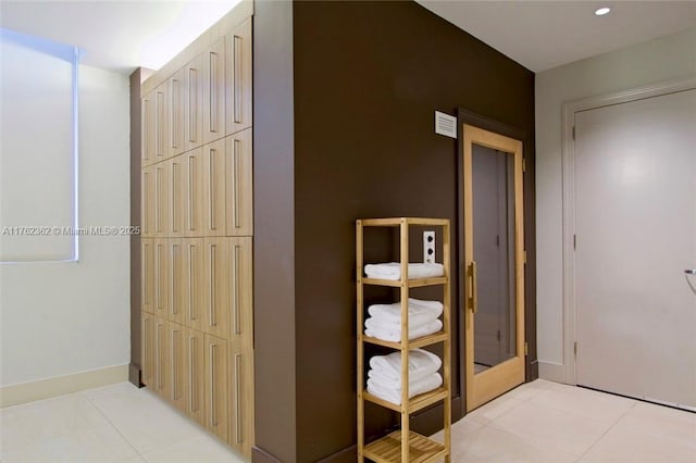 corridor featuring light tile patterned floors, visible vents, baseboards, and recessed lighting