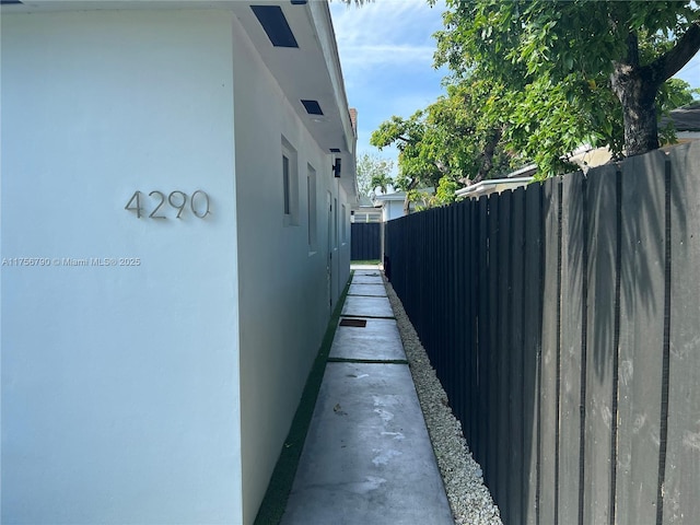 view of home's exterior with stucco siding and fence