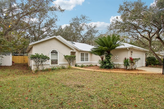 single story home with a front lawn, fence, stucco siding, driveway, and an attached garage