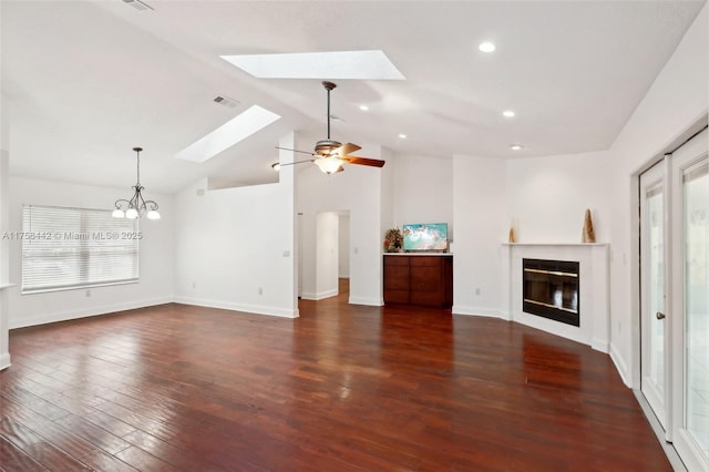 unfurnished living room with a wealth of natural light, a glass covered fireplace, a skylight, and wood finished floors