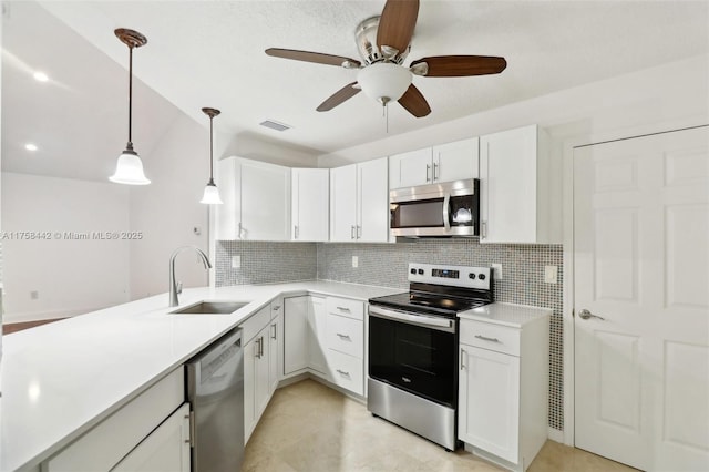 kitchen with backsplash, light countertops, white cabinets, stainless steel appliances, and a sink