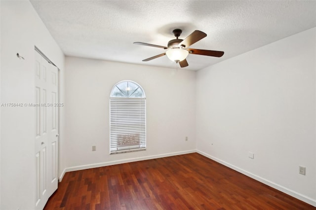 empty room featuring baseboards, a textured ceiling, wood finished floors, and a ceiling fan