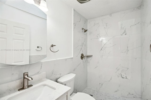 full bath featuring vanity, toilet, a marble finish shower, and a textured ceiling