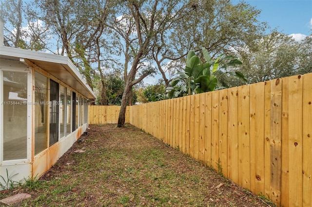 view of yard with a fenced backyard and a sunroom