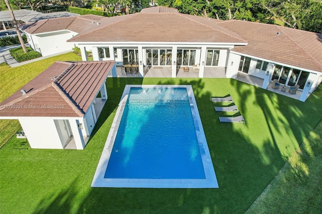 pool with a patio area and a lawn