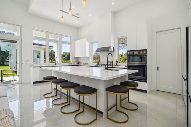 kitchen featuring white cabinetry, modern cabinets, a kitchen bar, and a healthy amount of sunlight