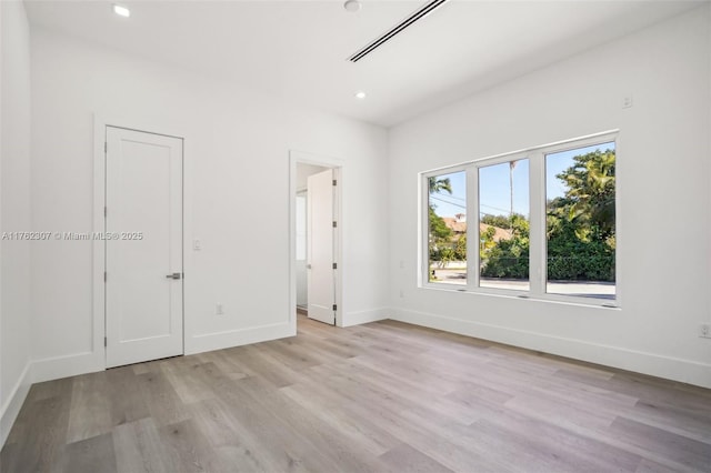 unfurnished room with visible vents, recessed lighting, baseboards, and light wood-type flooring