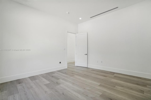 empty room featuring light wood-style flooring, baseboards, and visible vents