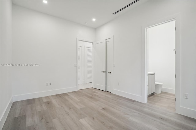 unfurnished bedroom featuring recessed lighting, light wood-style floors, and baseboards