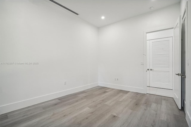 spare room with recessed lighting, light wood-style floors, and baseboards