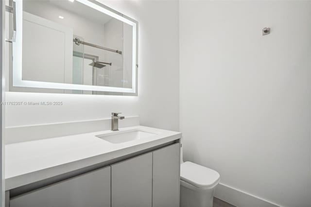 bathroom featuring vanity, toilet, and a stall shower