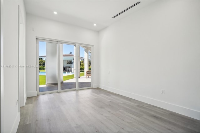 empty room featuring recessed lighting, visible vents, baseboards, and wood finished floors