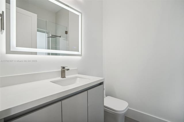 full bathroom with vanity, a shower stall, and toilet