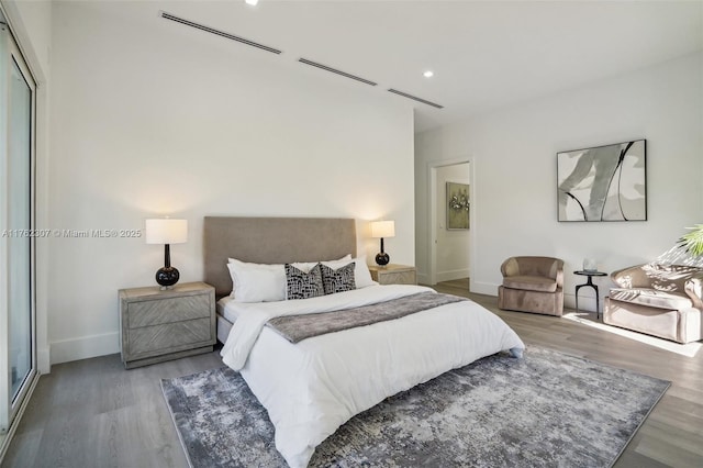 bedroom with recessed lighting, visible vents, baseboards, and wood finished floors