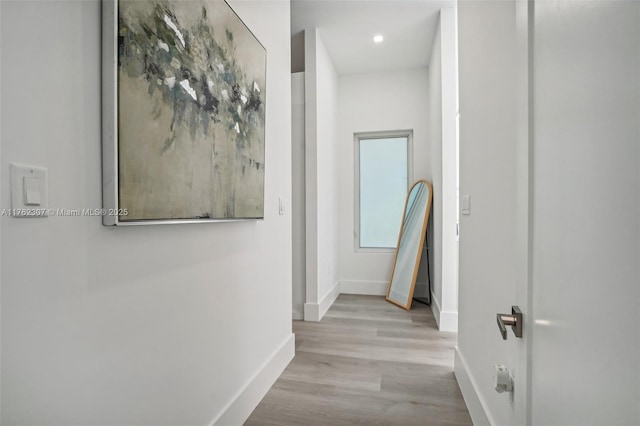 corridor with recessed lighting, baseboards, and wood finished floors