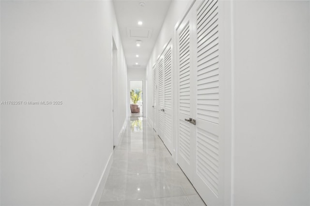 corridor with recessed lighting, marble finish floor, attic access, and baseboards