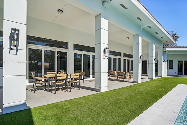 rear view of house featuring a patio area, stucco siding, and a yard