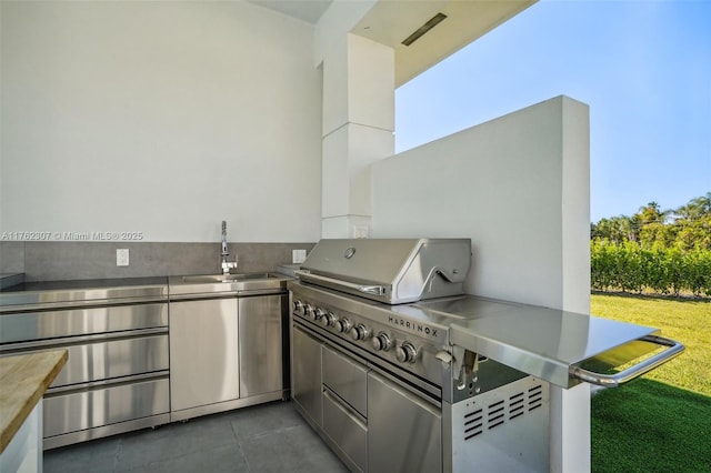 view of patio / terrace featuring an outdoor kitchen and a sink