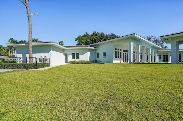 exterior space with central air condition unit, stucco siding, and a front lawn