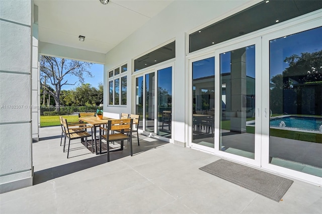 view of patio with an outdoor pool and outdoor dining area