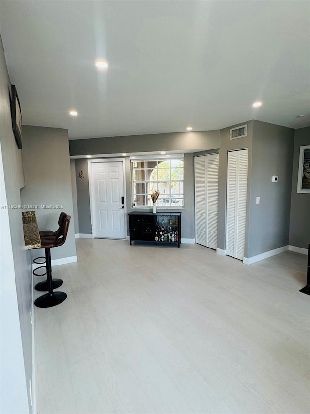 unfurnished living room with recessed lighting, visible vents, and baseboards