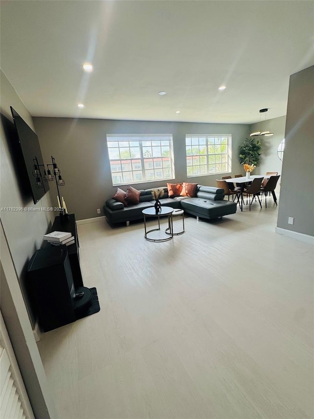 living area with recessed lighting, a healthy amount of sunlight, and baseboards